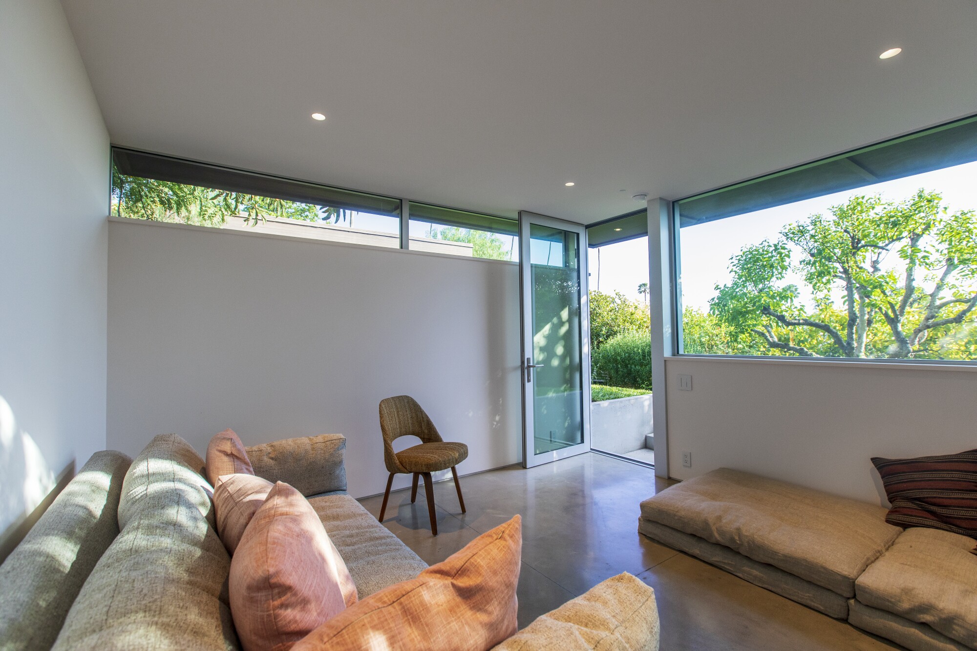 The interior of a small studio, with a tree visible outside through a window.