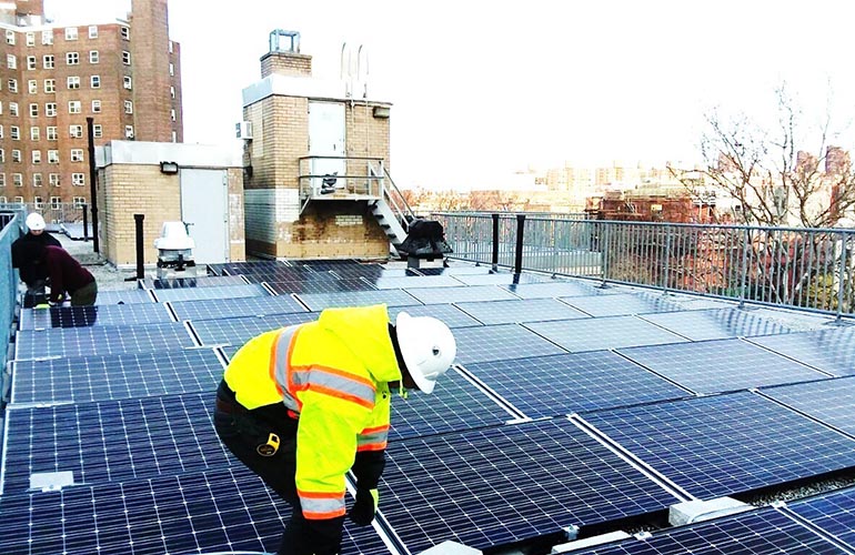 Workers installing solar panels at Carver Houses, a New York City Housing Authority development in northern Manhattan. Photo credit: Accord Power Inc.