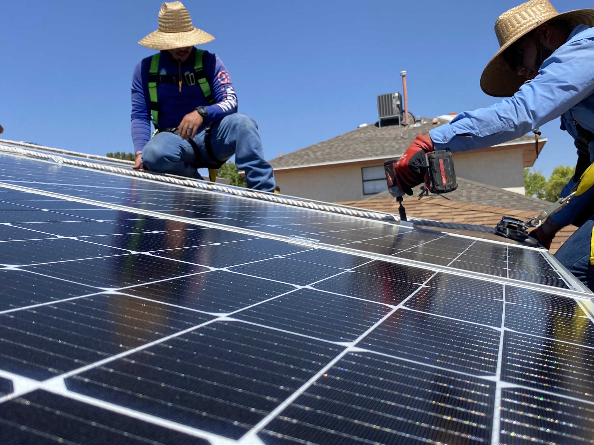 Solar Smart Living installers work on a residential rooftop.