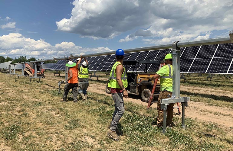 This photo was taken before enacting COVID-19 safety policies, but now Nexamp solar installers must do daily self-certification health reports, sanitize shared surfaces and wear gloves and masks to all worksites.