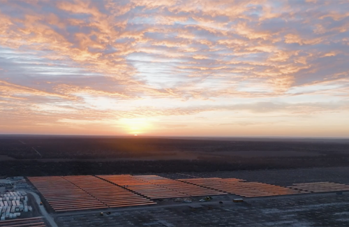 A photo of a utility-scale solar project shot at sunset.